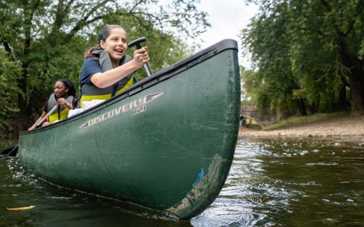 two students paddle a canoe on an outward bound expedition near DC